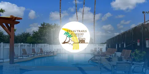 Poolside scene at Texas Trails RV Resort with lounge chairs and tall palm trees under a sunny sky.