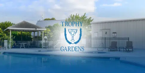 Poolside scene at Trophy Gardens with a pavilion and lounge seating under clear morning skies.
