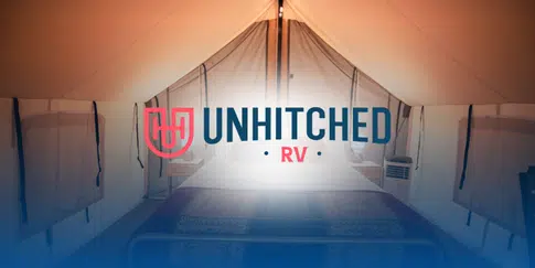 Glamping tent interior at Unhitched RV with a bed and soft lighting.