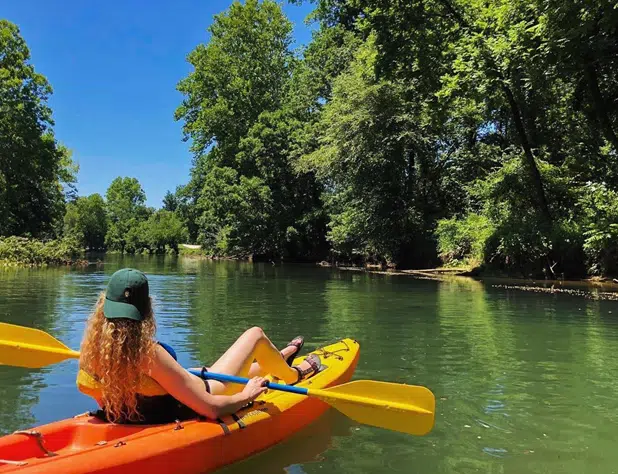 Visitors floating on inner tubes along the Chattahoochee River surrounded by trees and scenic river views.