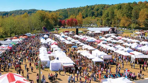 Visitors attending an outdoor festival in a North Georgia town, with local vendors, live music, and community activities.