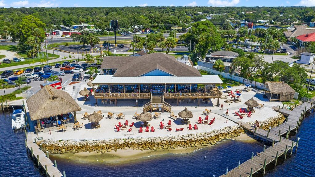 St. Pete Beach with wide sandy shoreline, turquoise Gulf waters, beachfront resorts, colorful umbrellas, and visitors enjoying a lively Florida beach day
