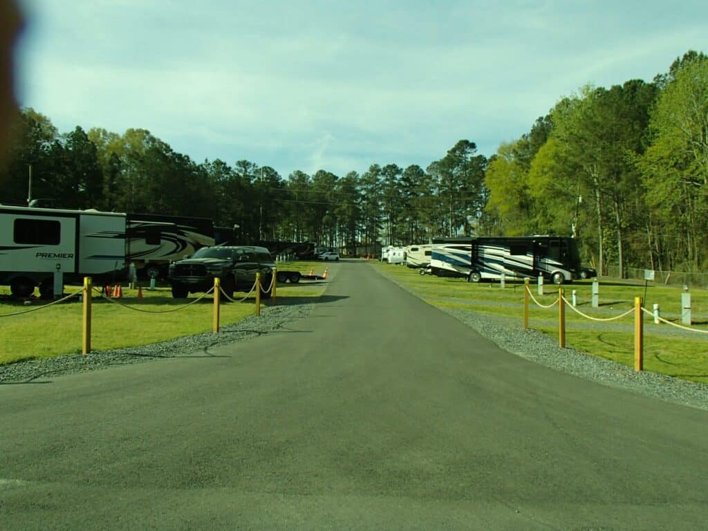 RV sites along a paved road at Forsyth KOA Journey.