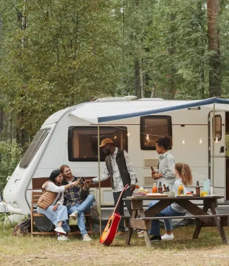 Two campers looking at a phone by a river