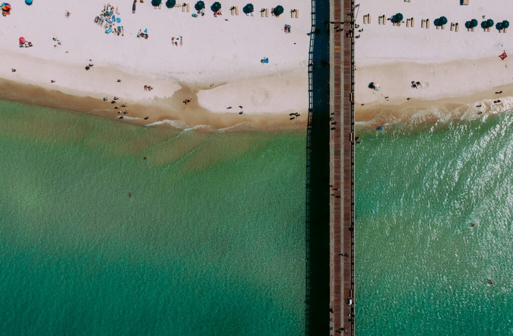 Aerial view of Panama Beach shoreline with pier, white sand, and turquoise water