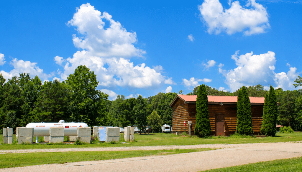Big Buck Resort log cabin building with propane station and RV campground surrounded by trees