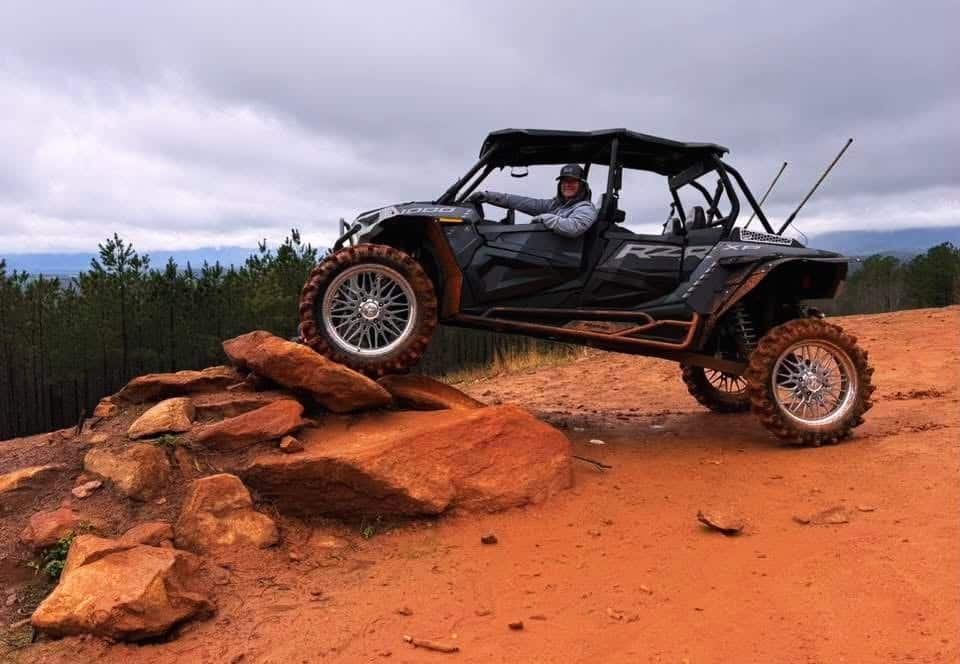 Off-road UTV climbing rocky terrain at Iron Mountain Park with scenic mountain views and rugged trails.