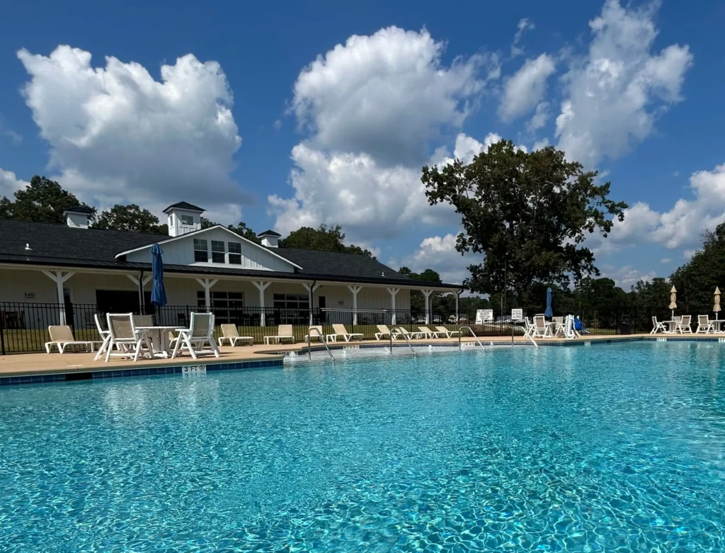 Large outdoor swimming pool with lounge chairs at Camp Cedar.
