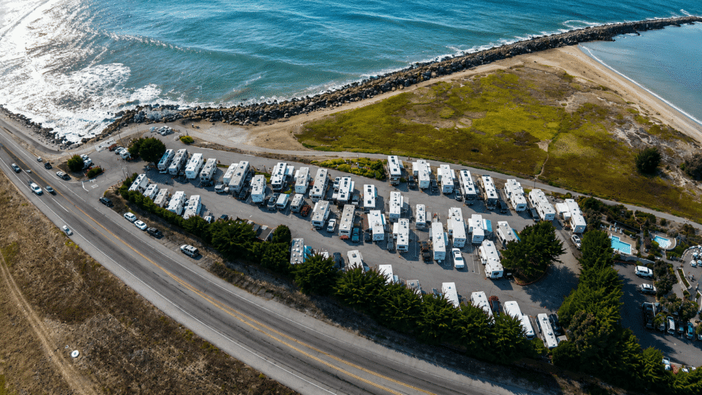Aerial view of Pillar Point RV Park with oceanfront campsites, rocky jetty, and scenic California coastline.